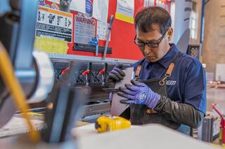 An IEM employee working with product components