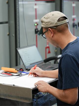 An IEM employee working on paperwork in a production context