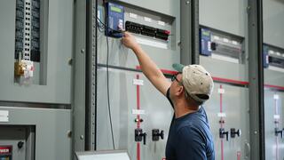 An IEM employee reaching for controls on equipment