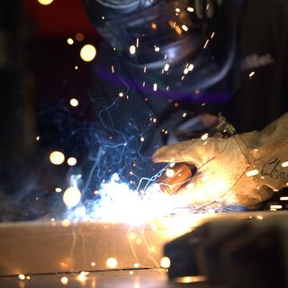 An IEM employee in the midst of welding