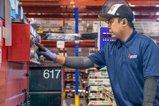 An IEM employee working with product