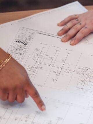 IEM employees collaborating over engineering drawings