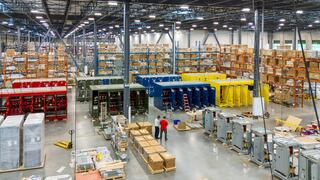 Two IEM employees in a large warehouse surrounded with IEM prouducs and equipment
